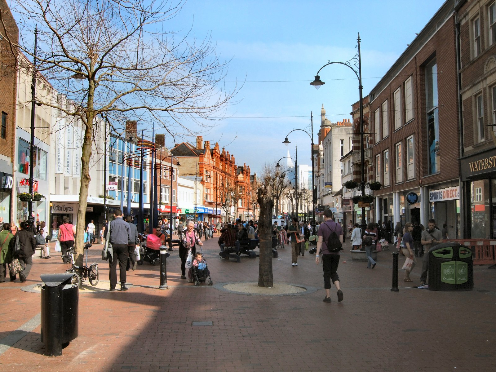 A busy pedestrian street with shops and people walking, reflecting the cultural vibrancy of Urdu poetry.
