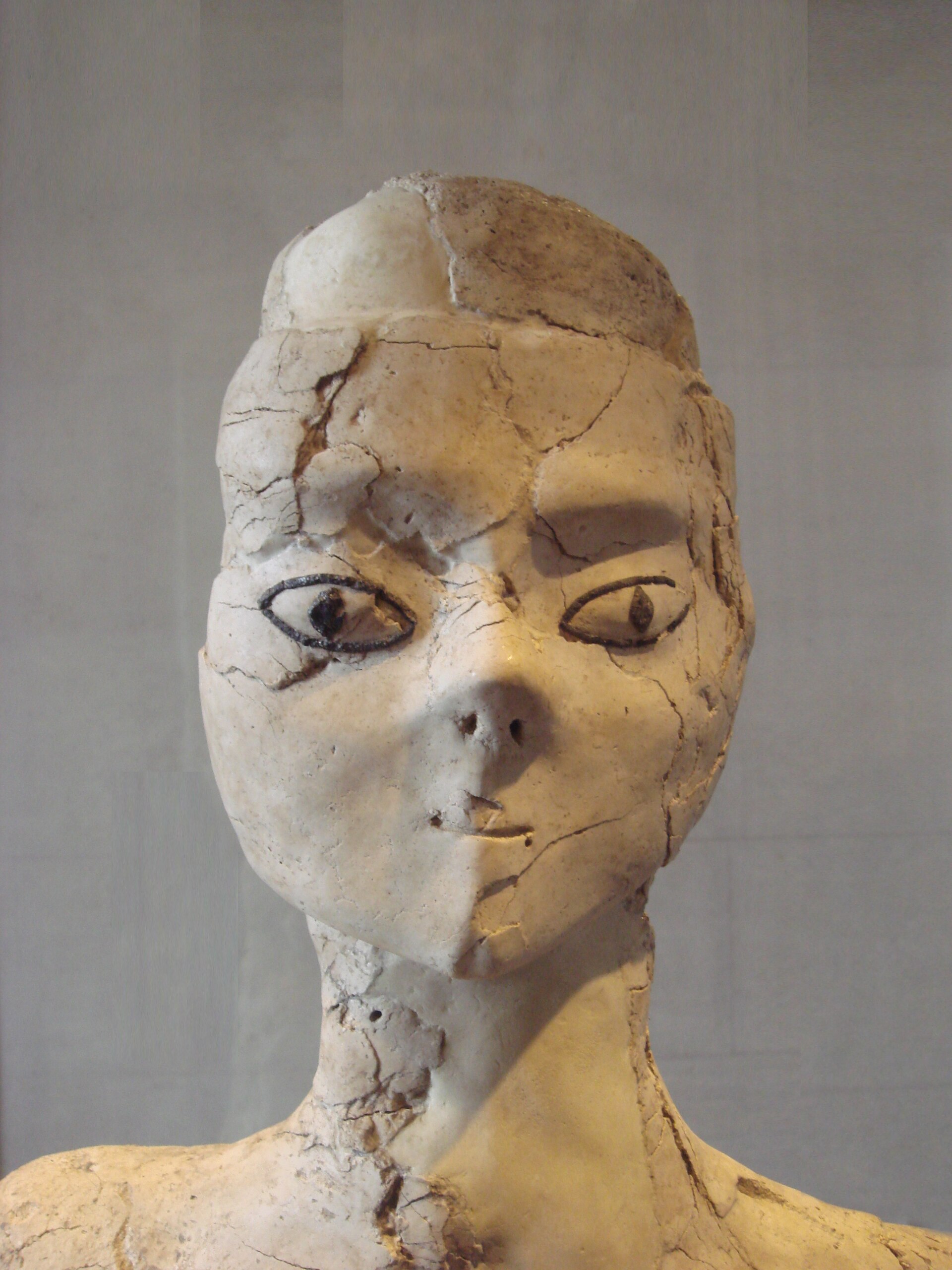 An ancient Egyptian limestone bust shows a serene face, reflecting the timeless beauty of art and culture.